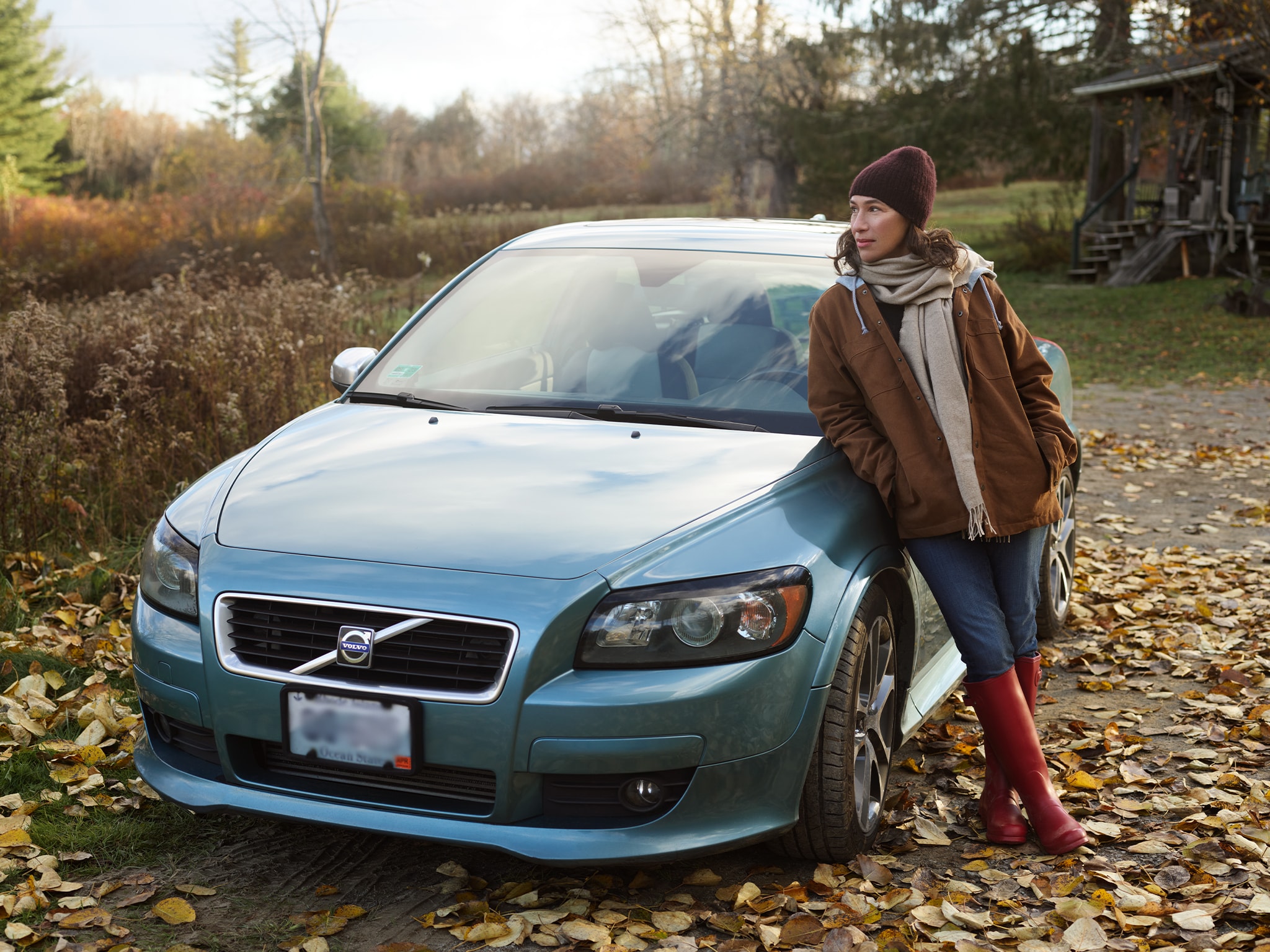 Woman in Brown Jacket Leaning on Volvo - Volvo Women's Stories Lila H.