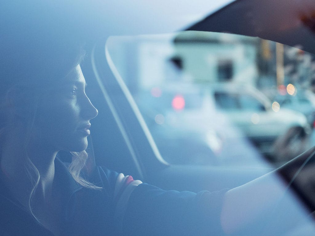Mujer sentada conduciendo un vehículo Volvo