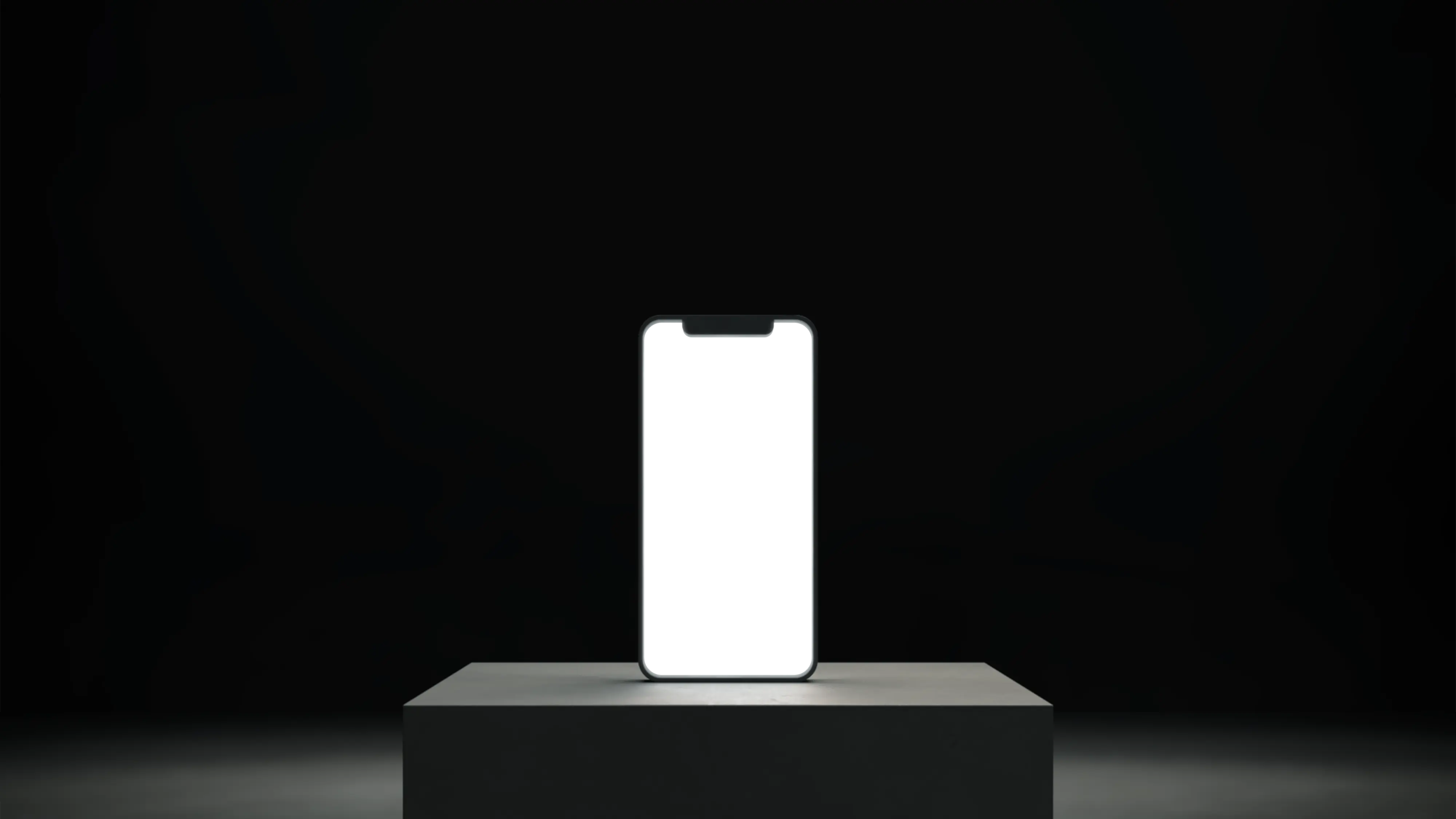 Teléfono sobre un soporte con una pantalla blanca vacía y encendida.