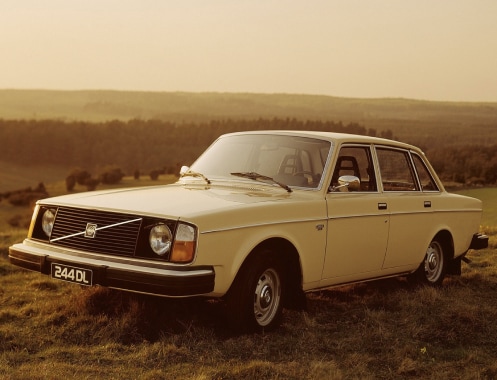 A Volvo 240 standing on a hill.
