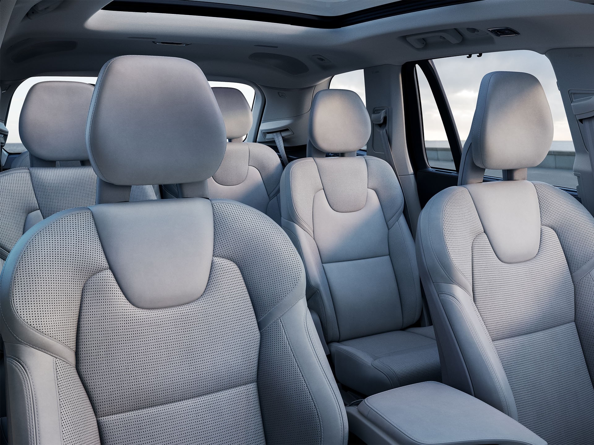 Dentro de un Volvo SUV con 3 filas, interior color claro en los asientos