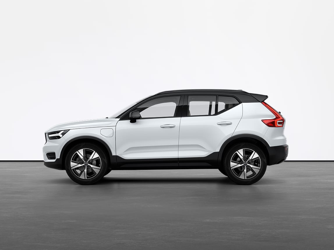 A crystal white Volvo XC40 Recharge plugin hybrid SUV standing still on grey floor in a studio