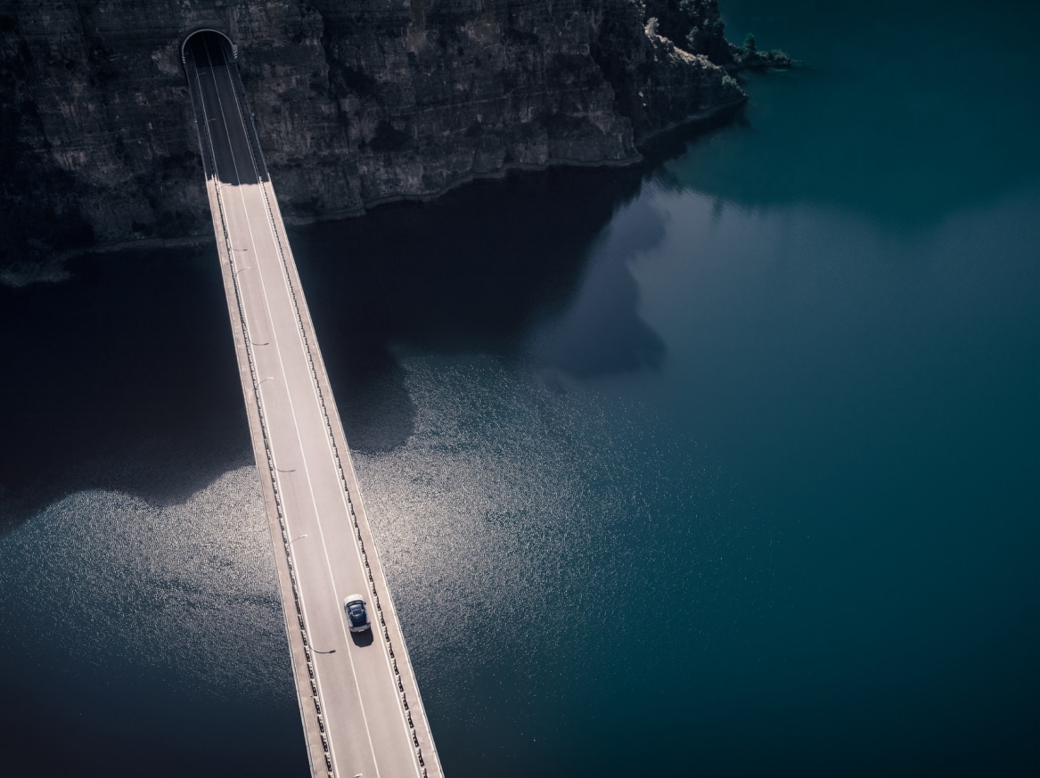 Ein vollelektrischer Volvo fährt auf einer Brücke.