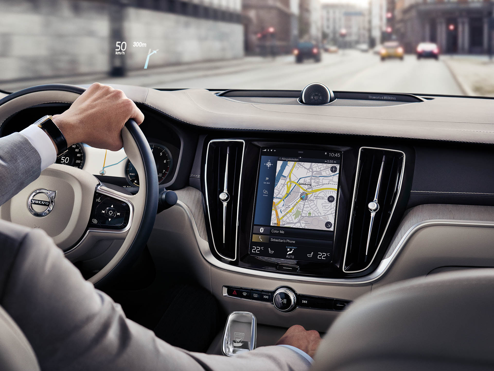 Volvo sedana salonā vīrietis brauc pa ceļu ar navigācijas sistēmas palīdzību