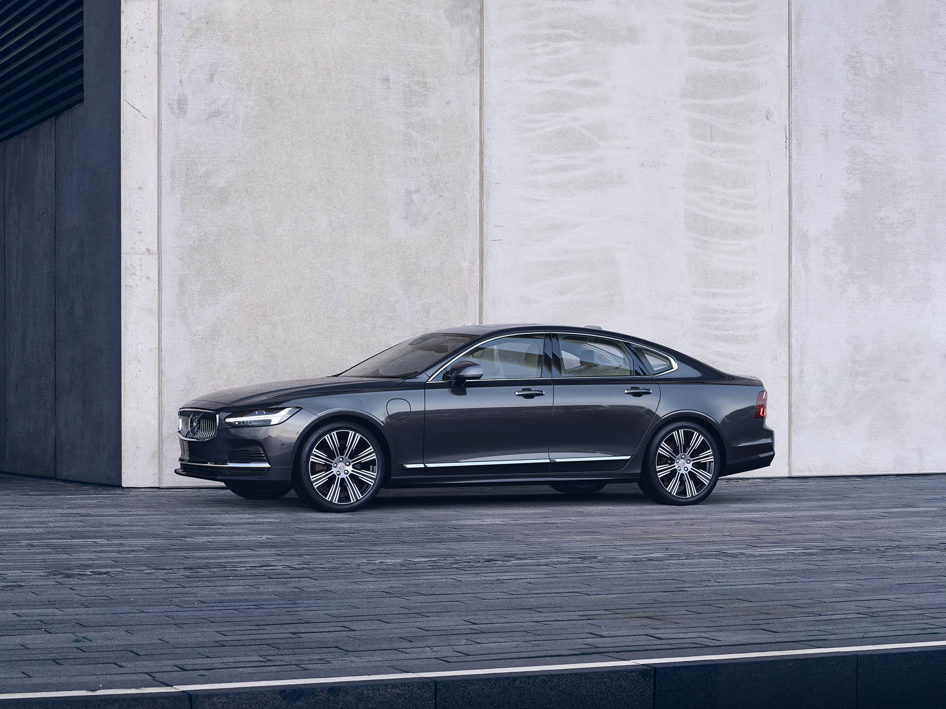 A Volvo S90 Sedan parked outside in front of a big wall