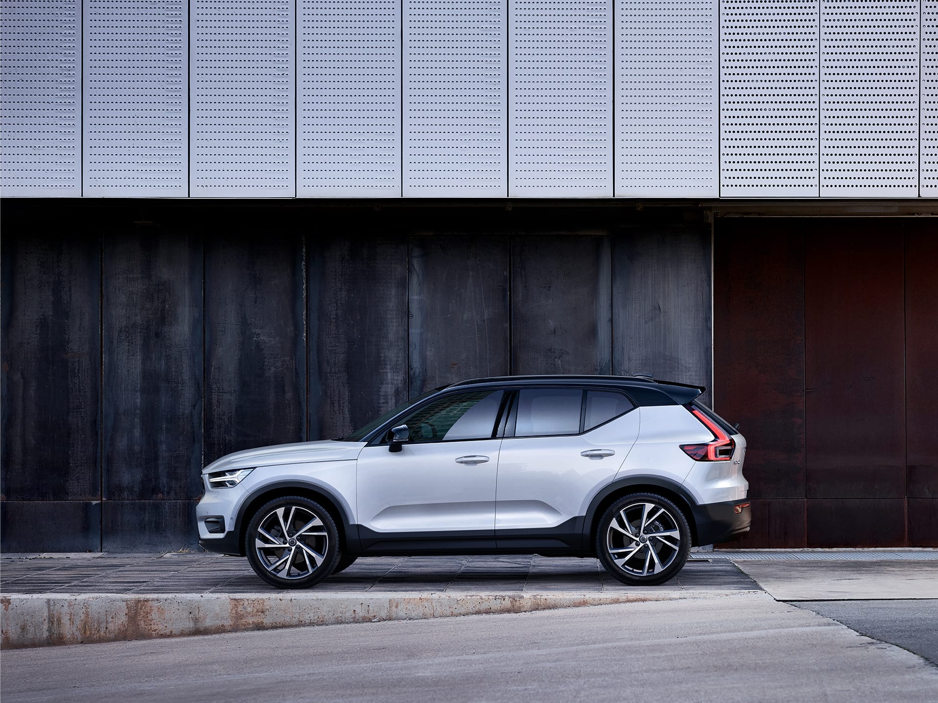 A white Volvo XC40 parked outside a building.
