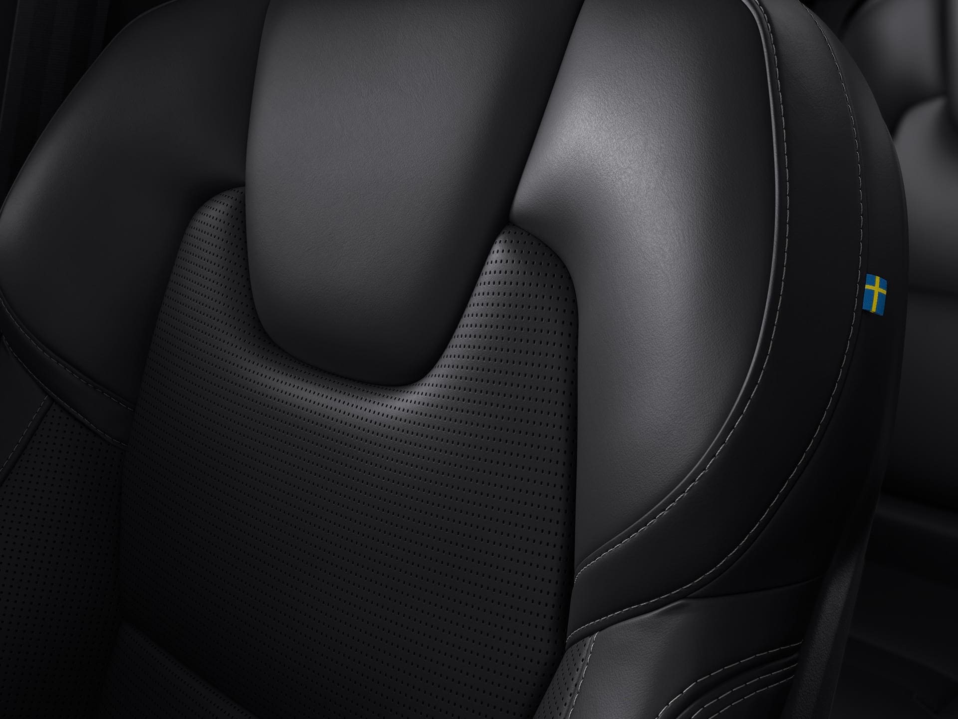 A close up of a black leather seat with ventilation and massage inside a Volvo.