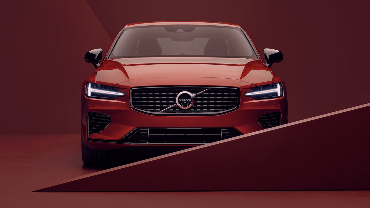 The front exterior of a red Volvo S60 in red surroundings.
