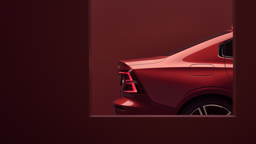 The rear of a red Volvo S60 in red surroundings.