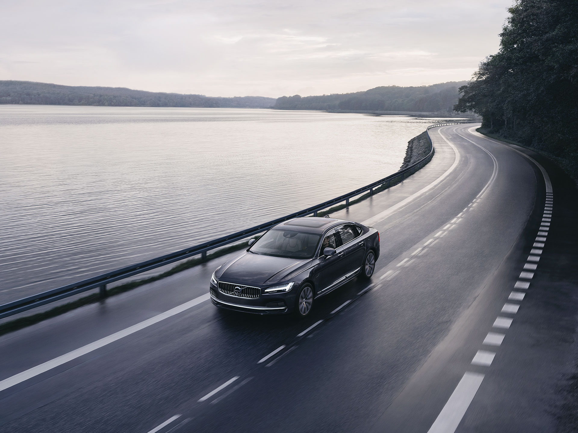 Mild hybridné Volvo S90 počas jazdy po ceste na pobreží.