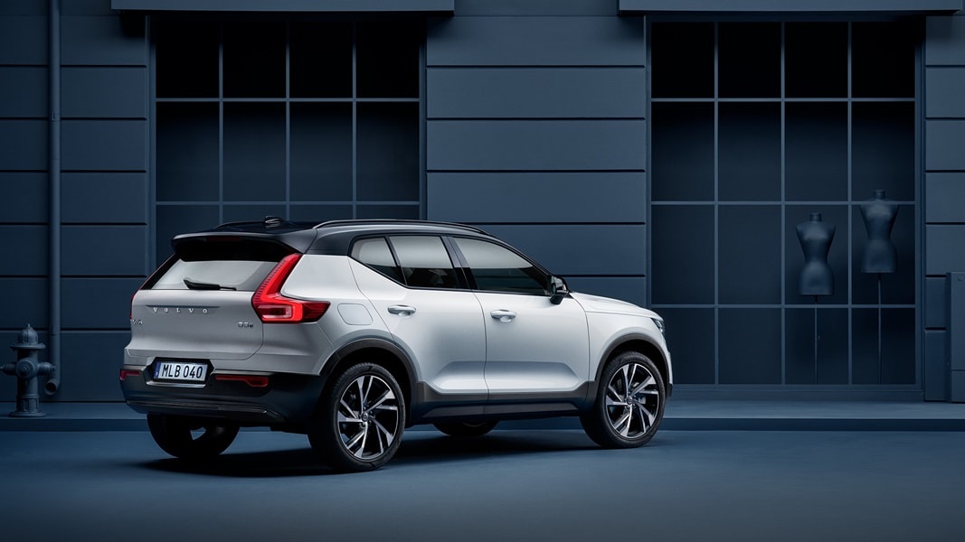 A Volvo XC40 stands parked alongside a blue facade.
