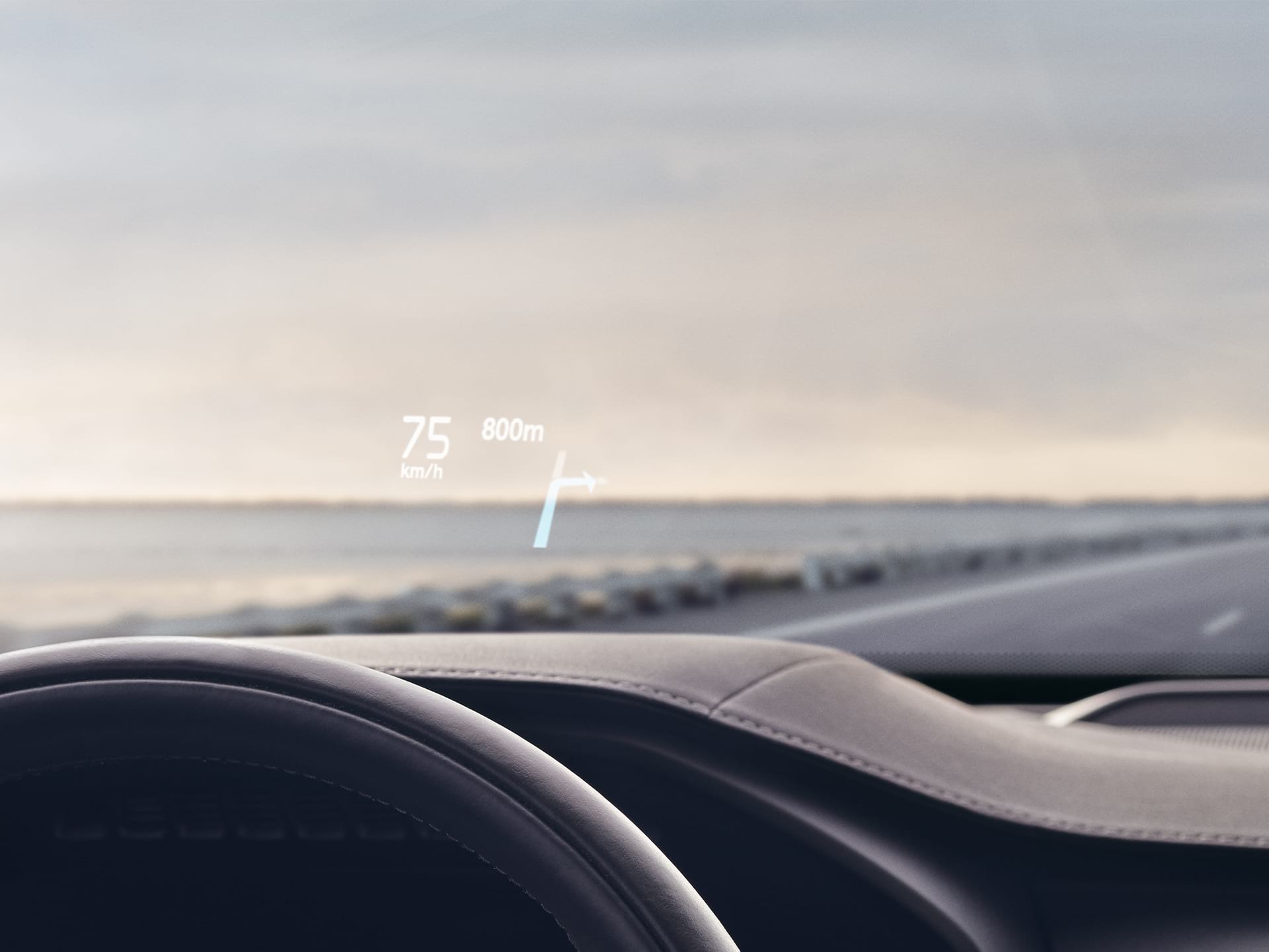 Inside a Volvo, head-up display showing driving speed and navigation on the windshield.