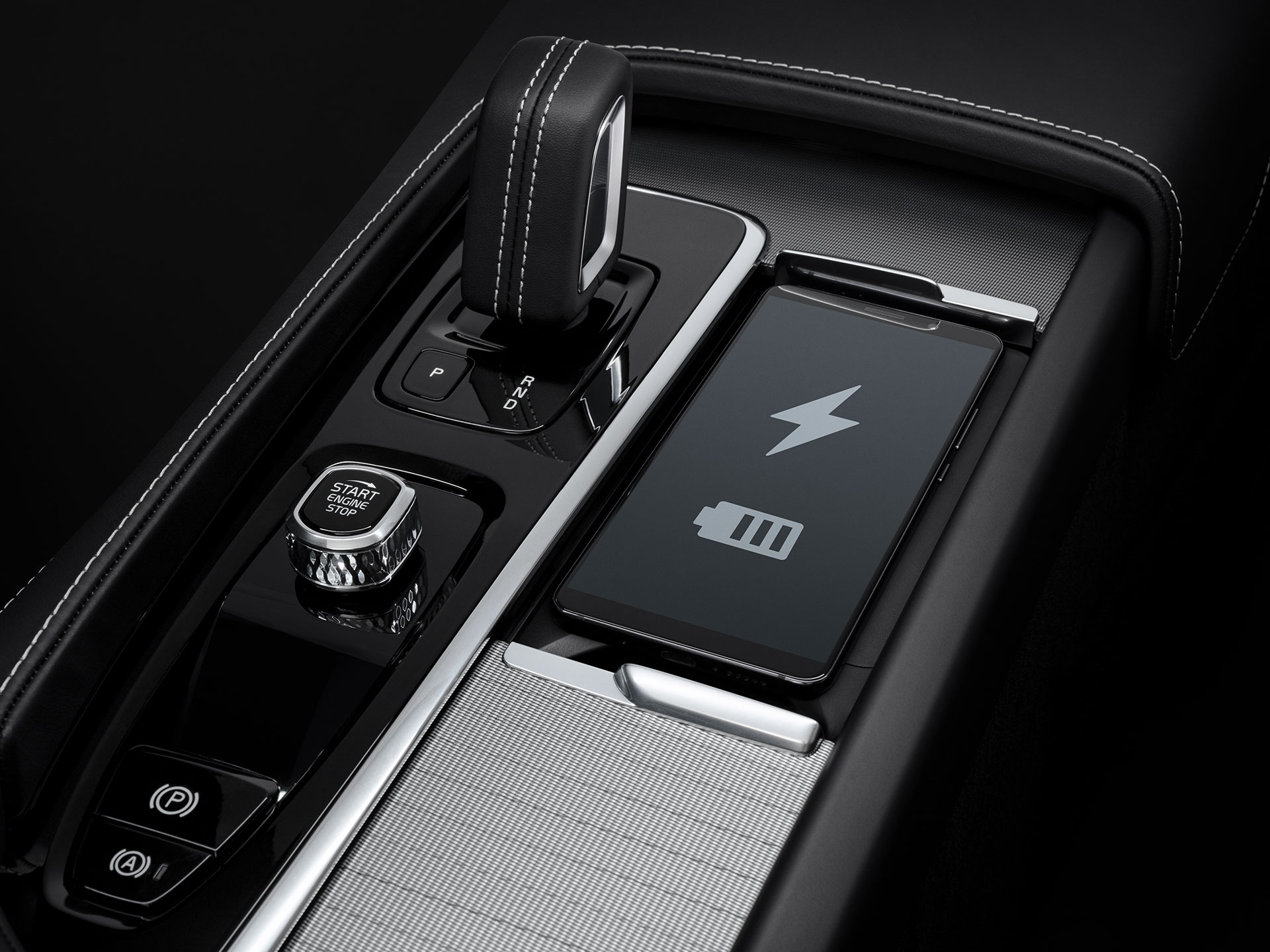 Dedicated smartphone storage space with wireless fast-charging for compatible devices inside a Volvo XC60.