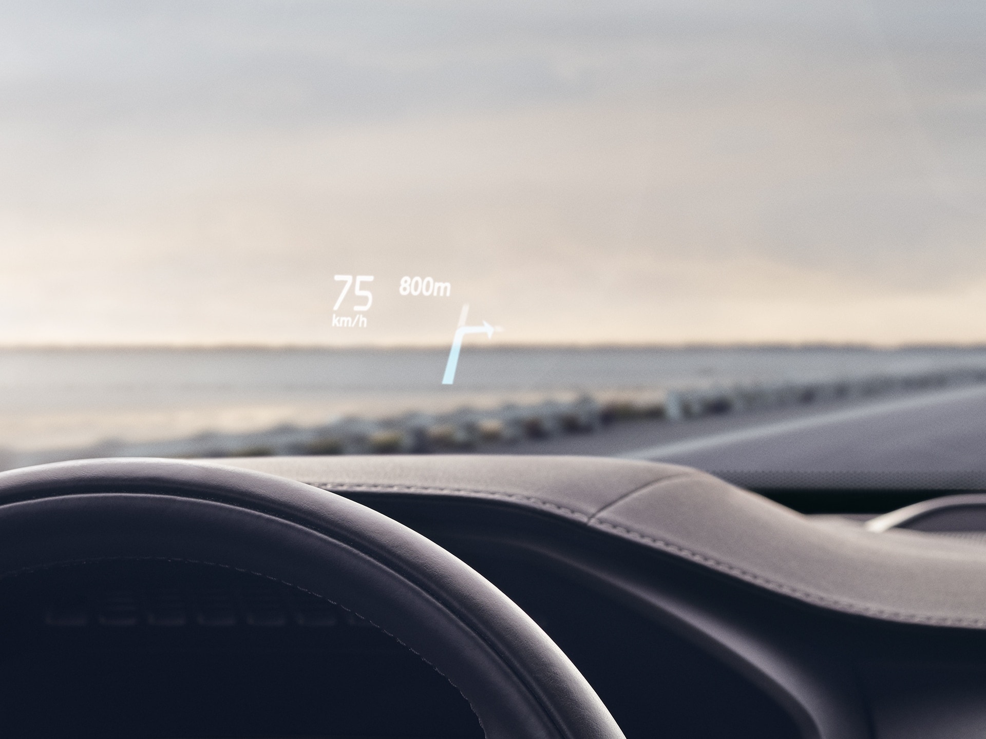 Inside a Volvo, head-up display showing driving speed and navigation on the windshield.