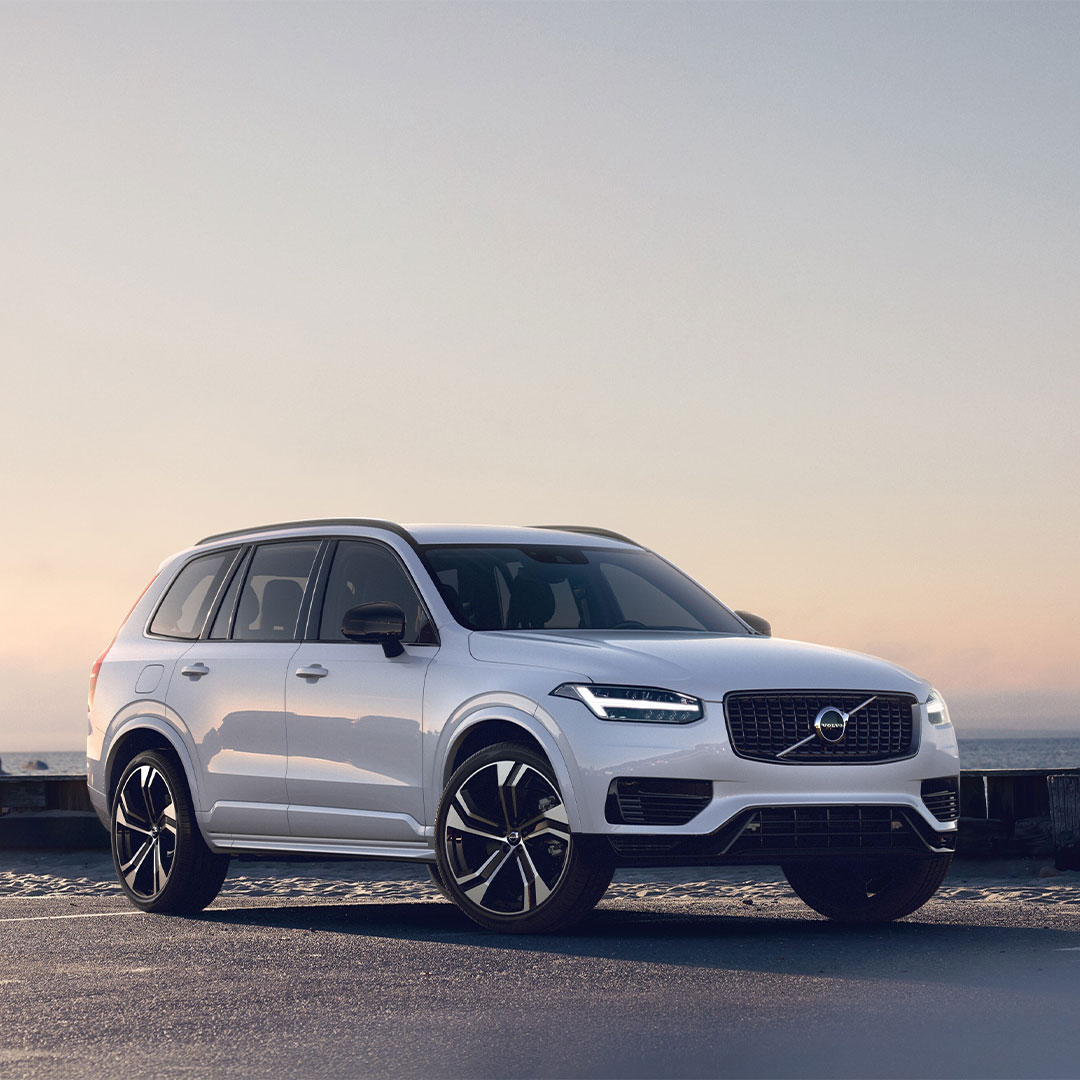 Front side view of XC90 Recharge parked on open road at sunset.