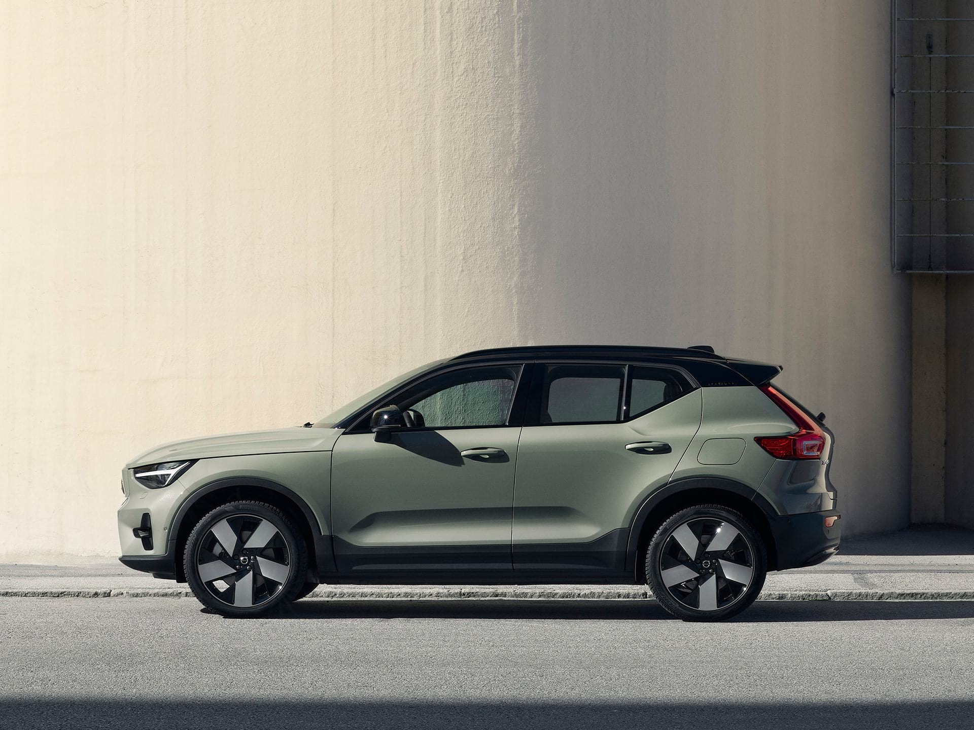 The side profile of a green Volvo XC40 Recharge pure electric SUV. 