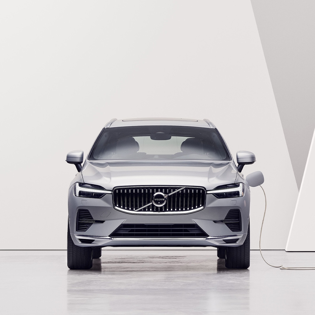 A grey Volvo car from above, being charged via a charging station