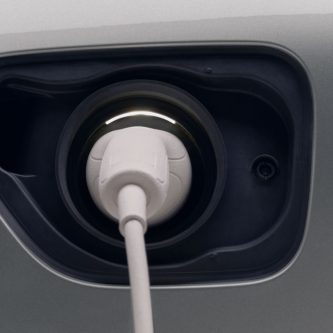 Um close-up de um cabo de carregamento conectado à porta de carregamento de um carro Volvo Recharge.