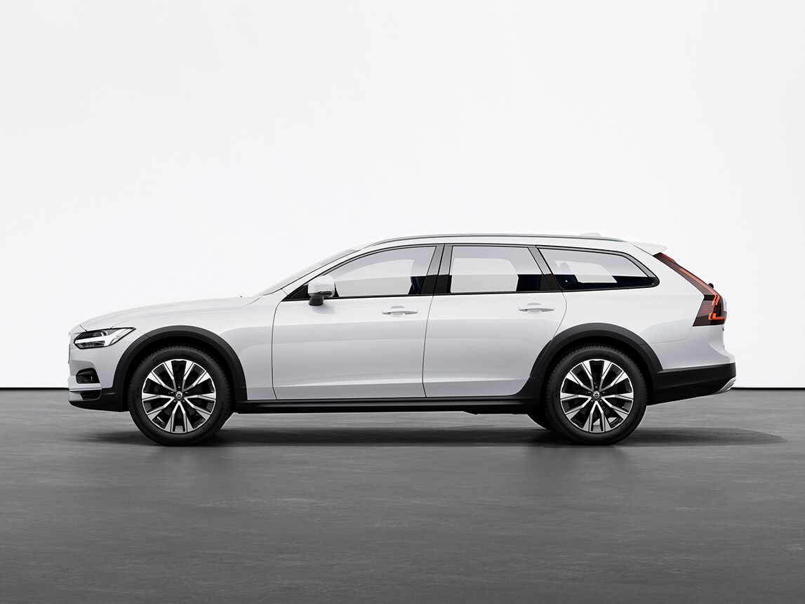 A crystal white pearl Volvo V90 Cross Country Estate standing still on grey floor in a studio