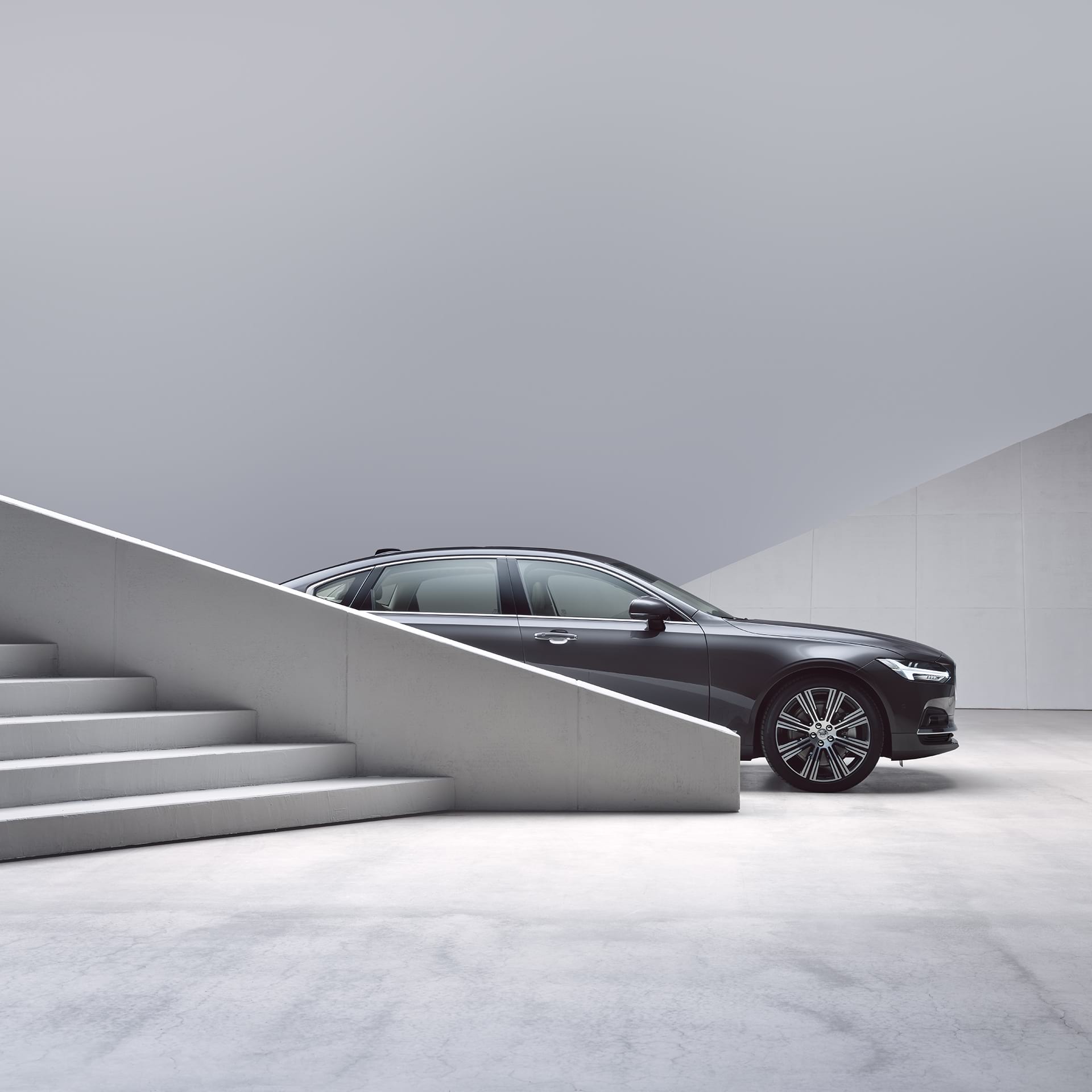 A Volvo S90 partially obscured by stairs
