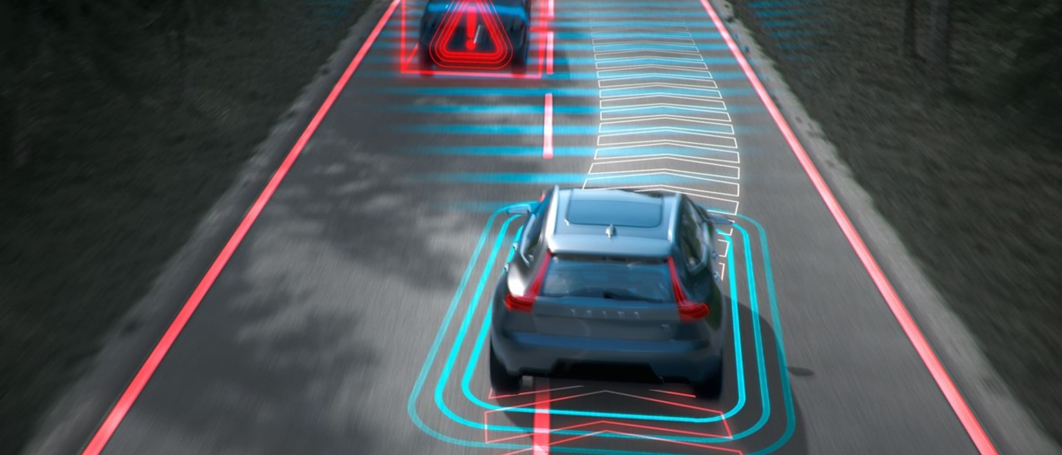 Ein Volvo fährt auf einer Autobahn mit digital gerenderten Schildern, die eine Abmilderung von Kollisionen mit dem Gegenverkehr durch Bremsen darstellen.