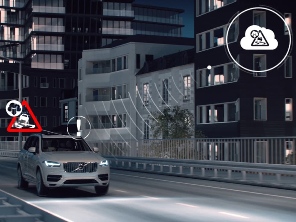 Volvo XC90 kjører på kveldstid i et bebygd område, og har et overlegg av digitalt gjengitte ikoner.