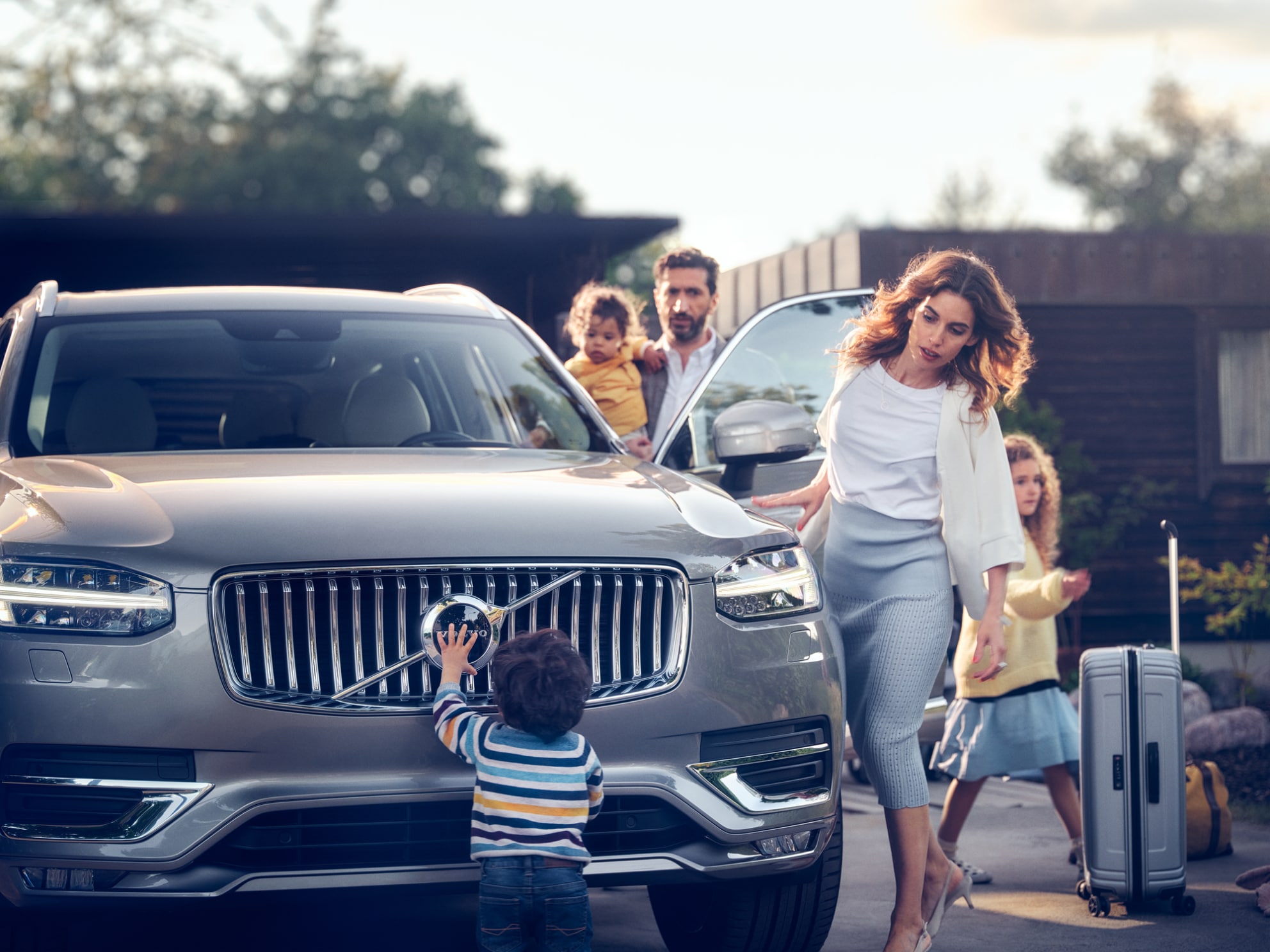 Uma família com três crianças prestes a entrar num Volvo