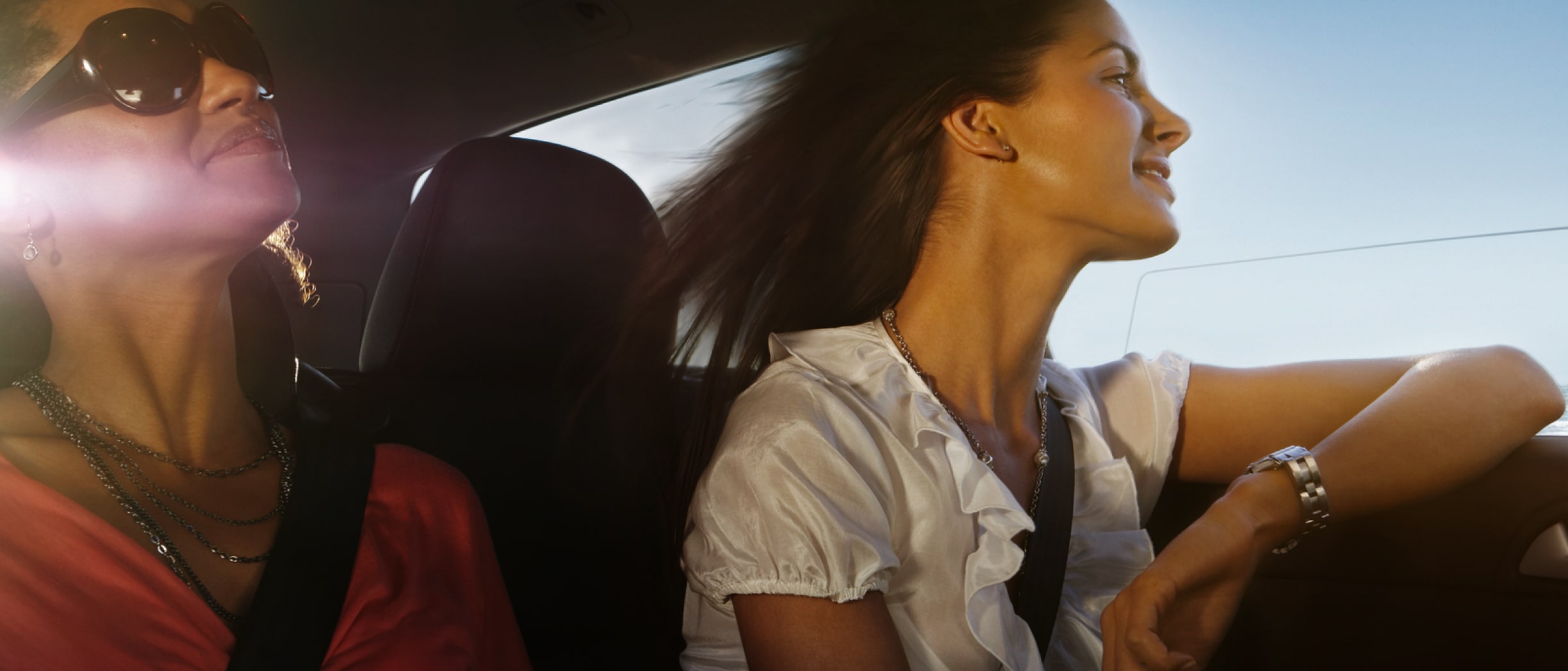 To kvinner i en bil gleder seg over en kjøretur