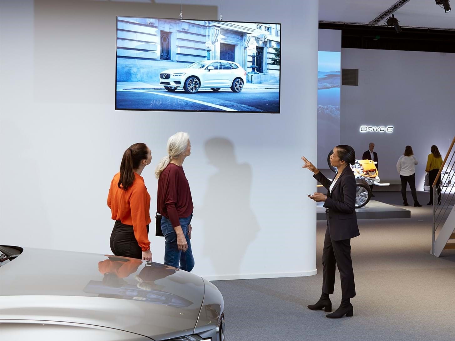 Besucher der Ausstellung im Volvo Cars Brand Experience Center schauen auf einen Bildschirm.